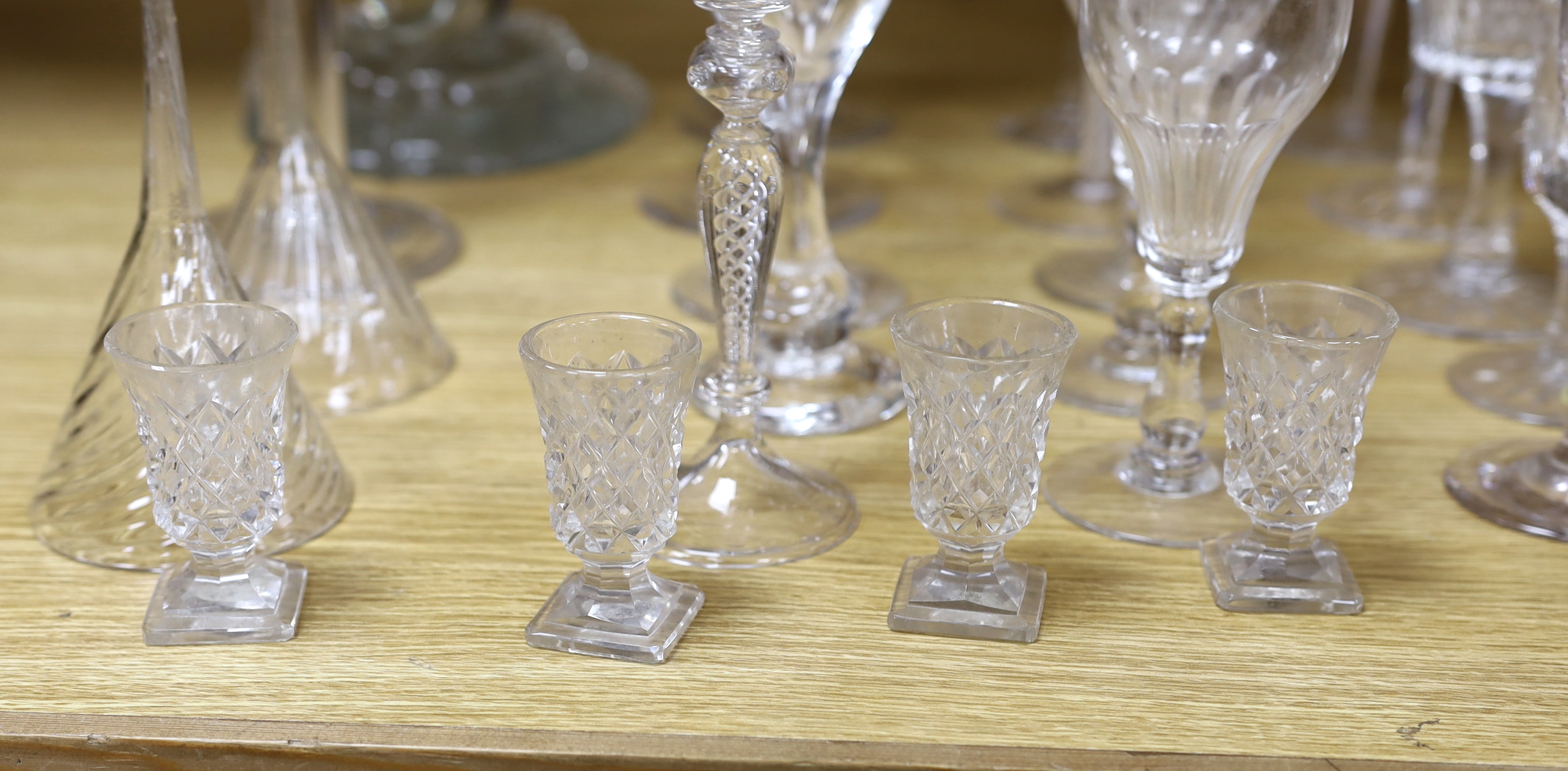 A large glass centrepiece, a teardrop trumpet shaped vase and a collection of 19th and 20th century wine and other drinking glasses